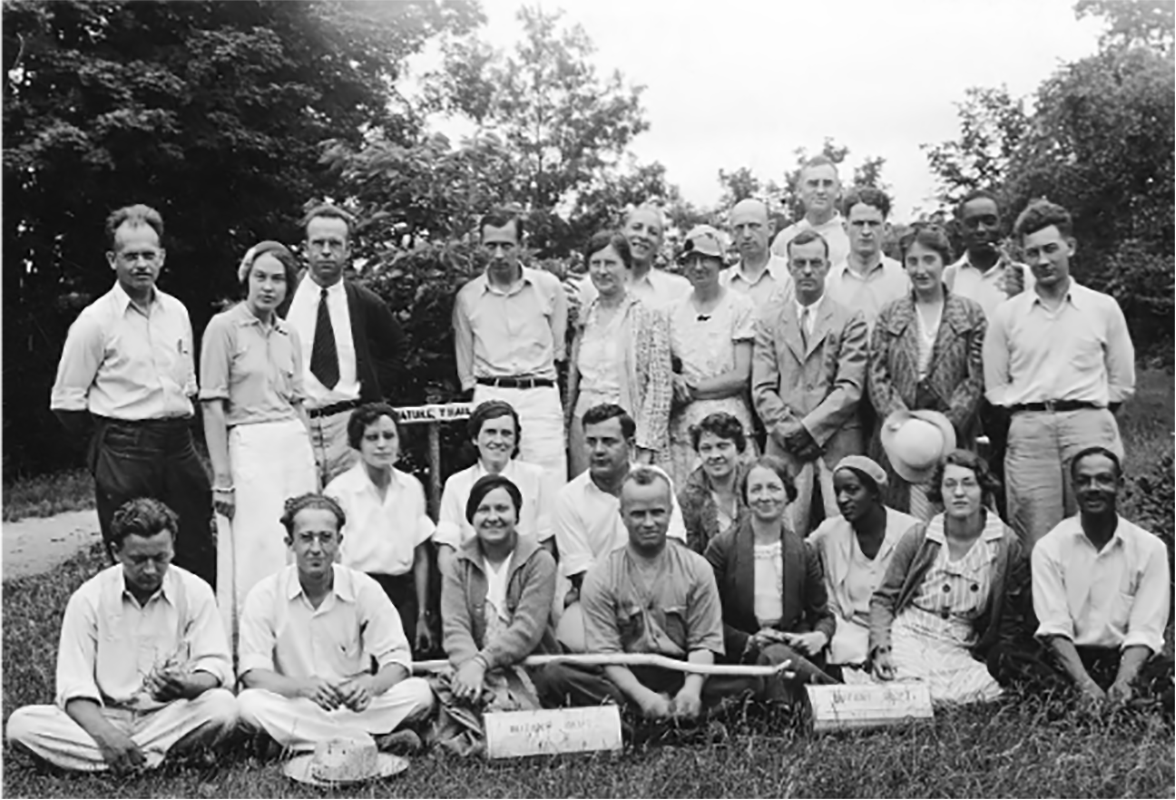 black and white photograph of a group of students posing outside with trees in the background