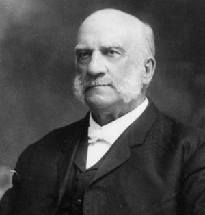 Black and white image of older white man with mutton chops and mustache, suit