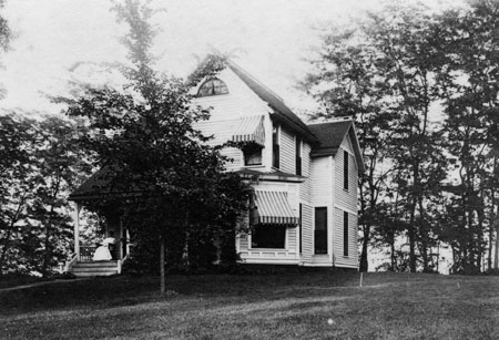 Medium two story house with covered windows and white paint