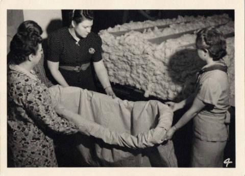 Black and white image of women preparing to stuff a mattress