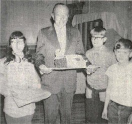Black and white image of Leopold with students from the Sperry school