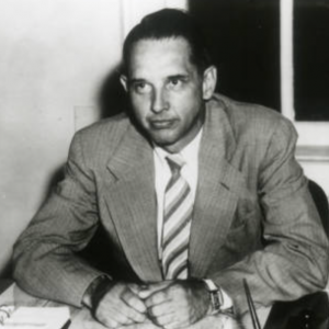 Black and white image of John Vincent Atanasoff sitting at his desk