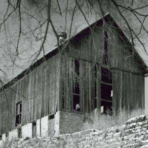 Black and white image of a barn partially dilapidated barn