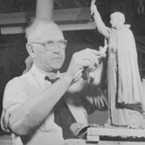 Black and white image of Christian Petersen sculpturing a small statue
